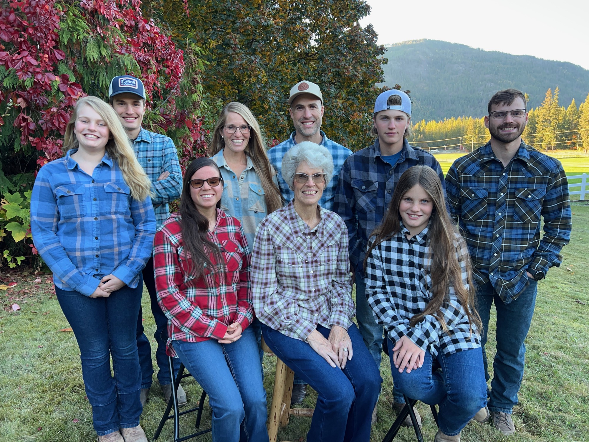 The whole McNeill family gathered in the field, fall colours on the mountains behind
