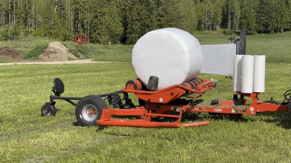 Bale wrapper sealing a round bale in white film