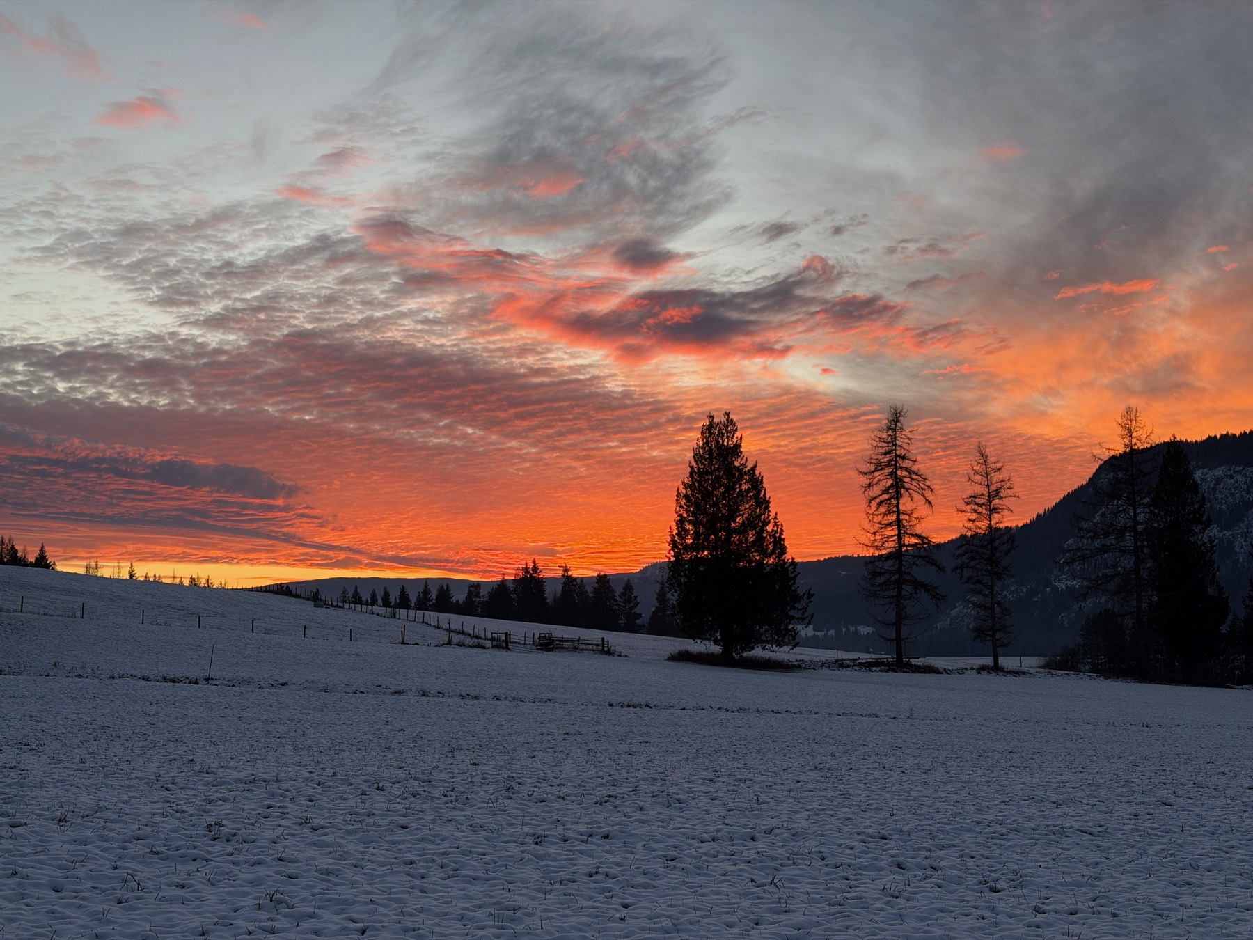 A fiery winter sunset over the snowed-in fields